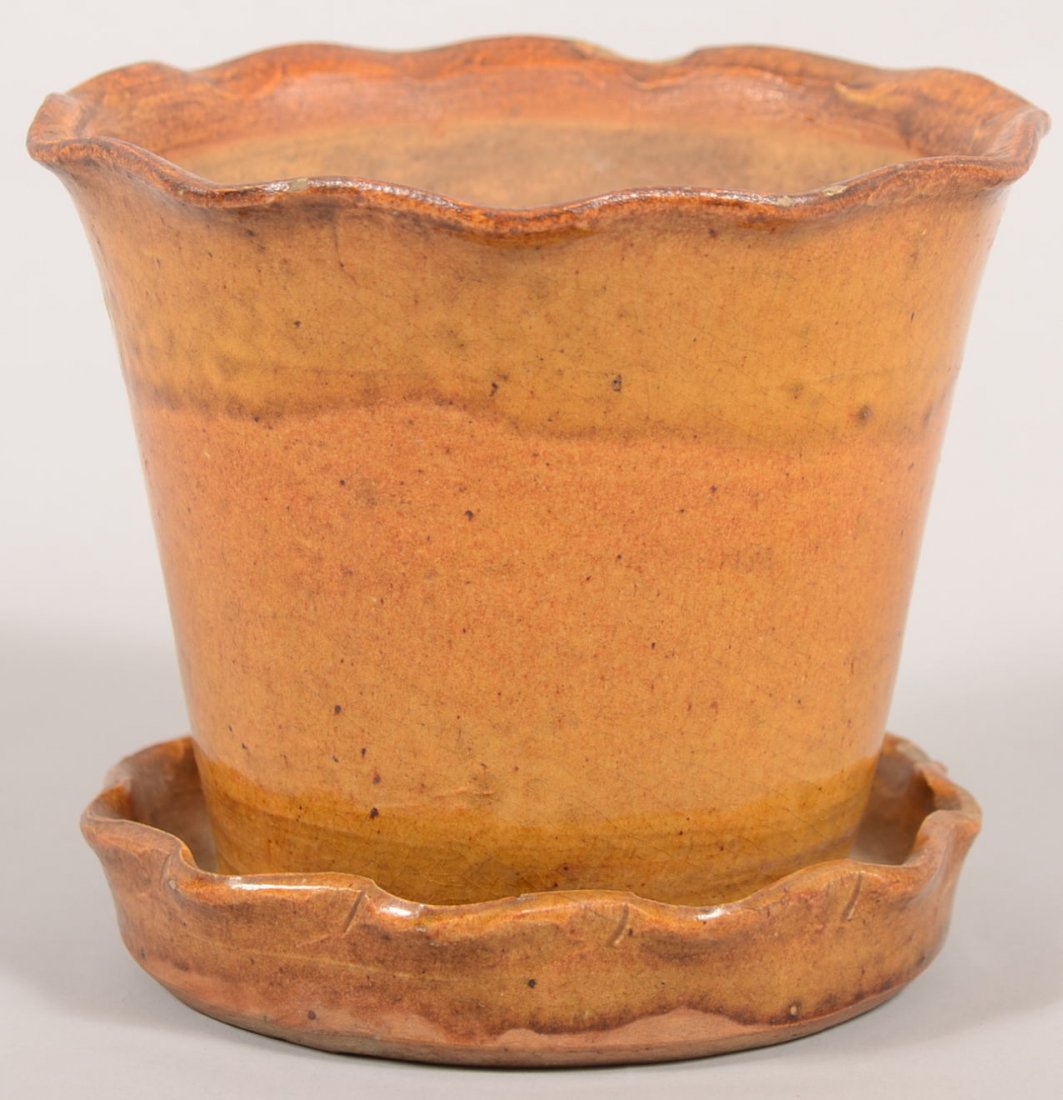Redware Flower Pot with Attached Saucer. Manganese and : Redware Flower Pot with Attached Saucer. Manganese and yellow mixed glaze decoration. Pot has a rippled rim with a drain hole in pot to saucer with rippled rim. 4 1/4"h. X 5 1/8"dia. Condition: One ch