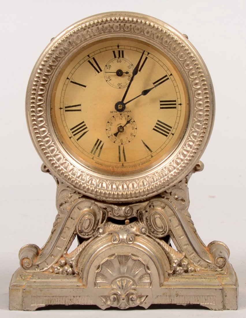 Seth Thomas Plated Pedestal Shelf Clock with Alarm. Pie: Seth Thomas Plated Pedestal Shelf Clock with Alarm. Pierced cast metal base contains dome shaped bell and alarm switch. Sheet metal works case has embossed bezel and Roman numeral printed dial paper s