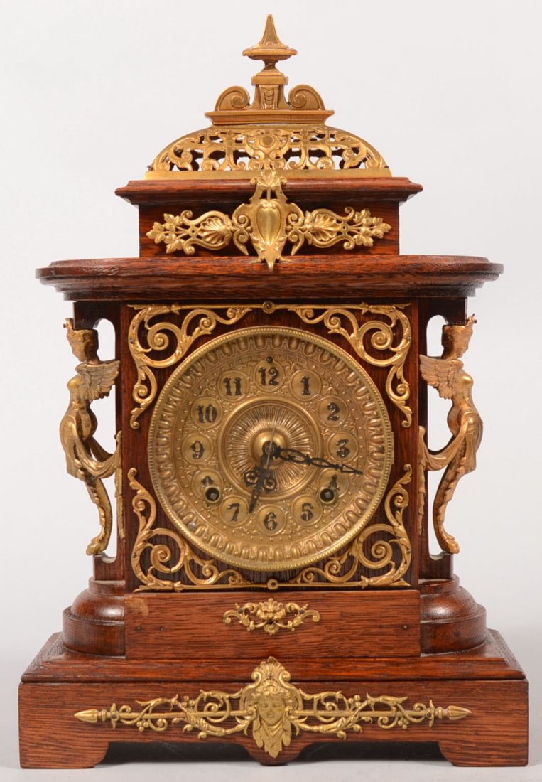 Ansonia Ornate Oak Cased Shelf Clock. Double spring dri: Ansonia Ornate Oak Cased Shelf Clock. Double spring driven brass works with pendulum and coiled gong. Access door on back. Refinished case is covered with brass ormolu including: Pierced loaf dome wit