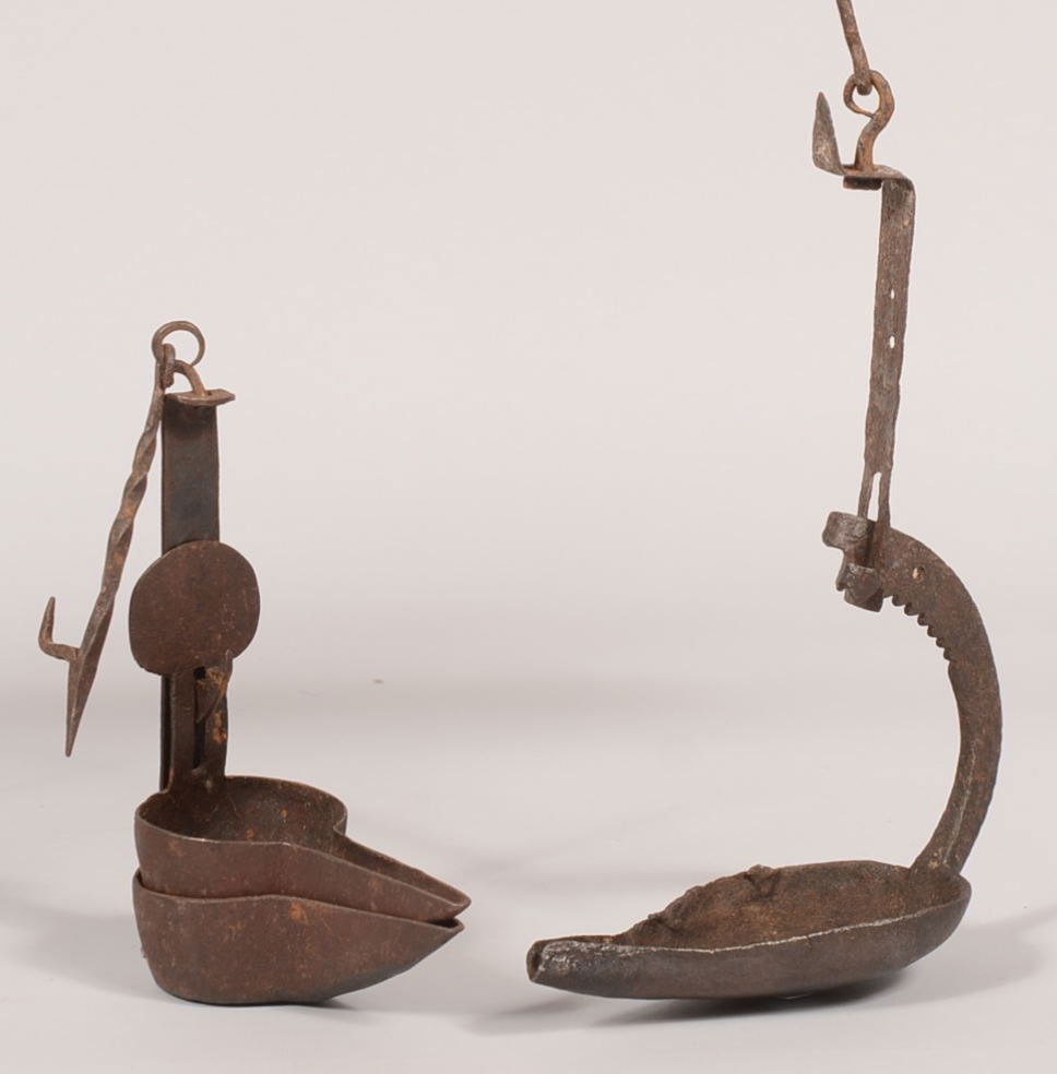 Two Primitive Wrought Iron Hanging Fat Lamps. Nested ci: Two Primitive Wrought Iron Hanging Fat Lamps. Nested circular pans with elongated spouts. Lower having the supporting hanging strap with swivel and twisted hook. Upper pan has a round finial with slot