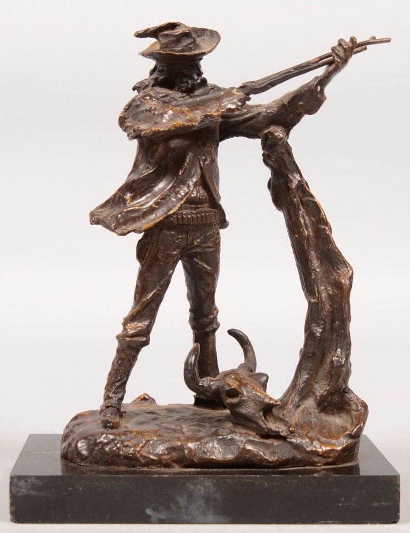 After C.M. Russell Signed Bronze of a Hunter. Wearing a: After C.M. Russell Signed Bronze of a Hunter. Wearing a feathered slouch hat, hunting frock, bullet belt on trousers stuffed into high boots. Man is aiming a rifle and resting on a tree stump with a s