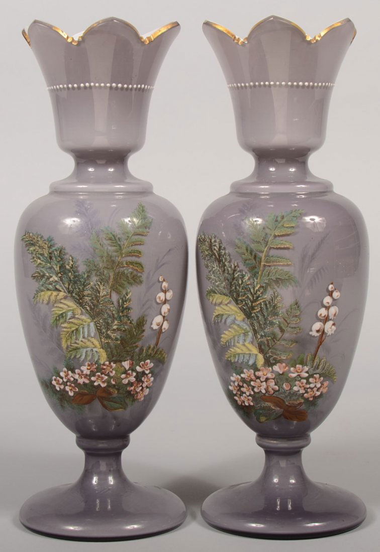 Pair of White Cased Amethyst Enameled Vases. Enamel pai: Pair of White Cased Amethyst Enameled Vases. Enamel painted floral spray on front, a single snowdrop on back, dotted line around mouth and gilt edging. Probably European. 13"h. Condition: Both good wi
