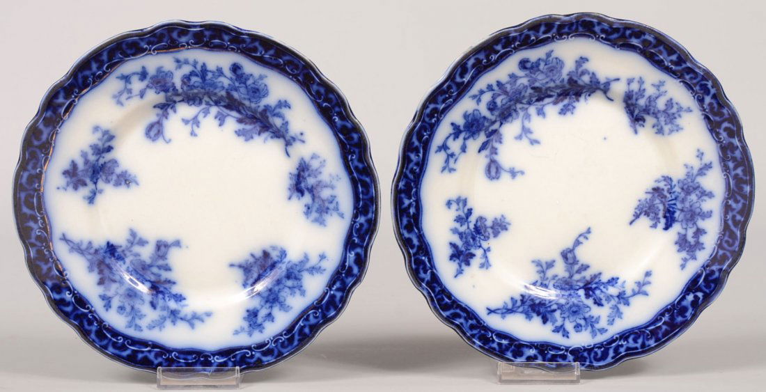 Two "Touraine" Pattern Flow Blue Plates. Dark blue band: Two "Touraine" Pattern Flow Blue Plates. Dark blue band around the scalloped rim. Inner border decorations extend into center. 8 3/4"dia. Condition: One has three small chips off under rim. Other good