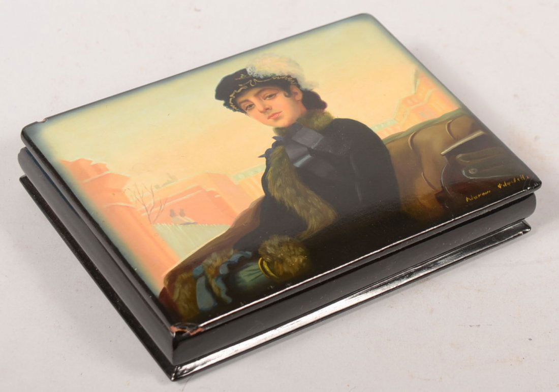 Hand Painted Trinket Box of Woman in Coach. Maybe Russi: Hand Painted Trinket Box of Woman in Coach. Maybe Russian or Eastern European, signed but not discernible. Black enameled box with red enameled interior bears the image of a young woman in velvet mop