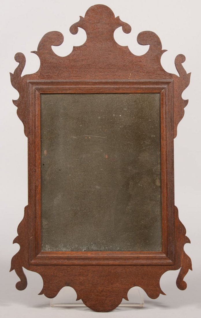 Small Chippendale Mahogany Looking Glass. Silvered glas: Small Chippendale Mahogany Looking Glass. Silvered glass surrounded by a low profile molded frame with applied head, foot and wings. 19 3/4"h. X 11 3/4"w. Condition: Piece of lower right wing re-glued