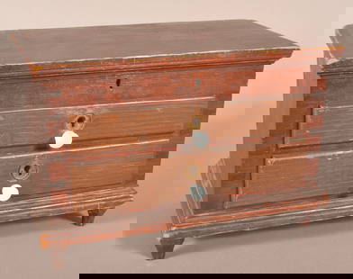 Lancaster Co. Painted Softwood Miniature Chest.: Attributed to Henry Lapp. Circa. 1880-1890. Original red paint with grain painted drawers, molded hinged lid, dovetailed case and two full-width nailed drawers, molded base and carved paneled feet. Pr