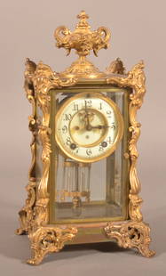 Antique Ansonia Brass Case Carriage Clock.: Ornate case with gilt-decorated bronze ormolu mountings and urn finial. Enameled dial, chiming brass works and mercury filled pendulum. 14" H x 8-1/4" W x 7-1/4" D