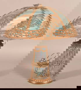 Early 20th Century Slag Glass Table Lamp.: Attributed to Edward Miller, Meridian, CT. Opaque, purple and blue slag glass with lighted base, gilt, spelter metal vase, bird, foliate and scroll designs. 22-1/2" H x 19-1/2" diam.