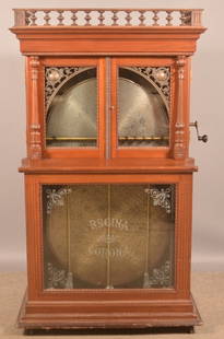 Regina Orchestral "Corona" Disc Changer Music Box.: Victorian mahogany case music box with twelve 27" discs. Bronze castings adorn the top of corners of the two front doors and are flanked by carved columns. Serial # 47493. 66-1/2" H x 39" W x 25" D