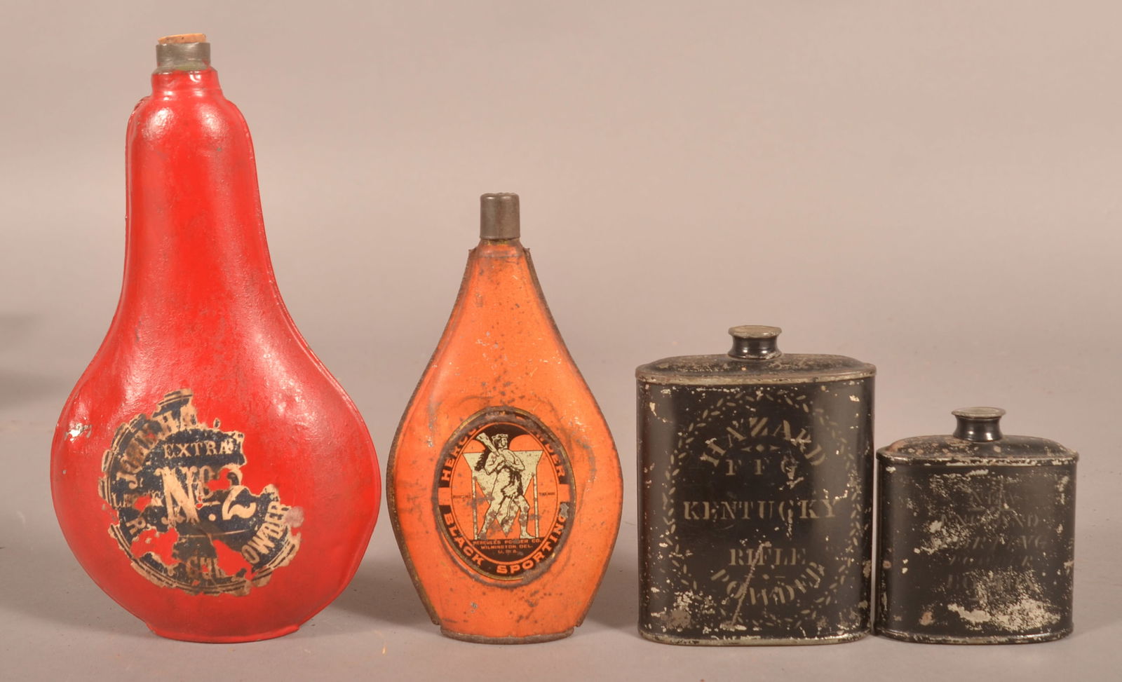 Group of Gunpowder Flasks.: Four total including two early stenciled Japanned Tins. Larger stenciled tin with "Hazard FF Kentucky Rifle Powder", filled with shot. Orange teardrop-shaped tin marked "Hercules Powder". Largest flas