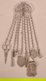 19th Century Polished Steel Chatelaine.: Waist clip with exotic birds at water fountain and eight various accessories. 13-1/2"l., waist clip 3"w.