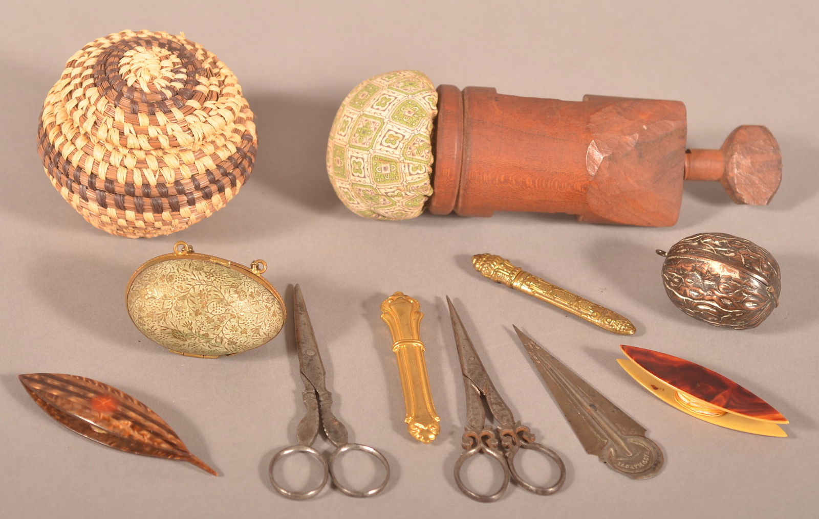 Lot of Antique/Vintage Sewing Accessories.: Including a cherry C-clamp pin cushion, two metal needle cases, two pairs of iron scissors, two celluloid shuttles, metal walnut-form thimble case with thimble, metal egg-form thimble case with thimbl
