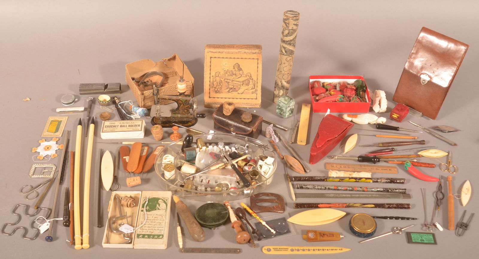 Lot of Antique/Vintage Sewing Tools & Accessories.: Including a child's sewing machine, thimbles and cases, needle cases, scissors, etc. Box measures 1-1/2"h. x 17"w. x 14"d.