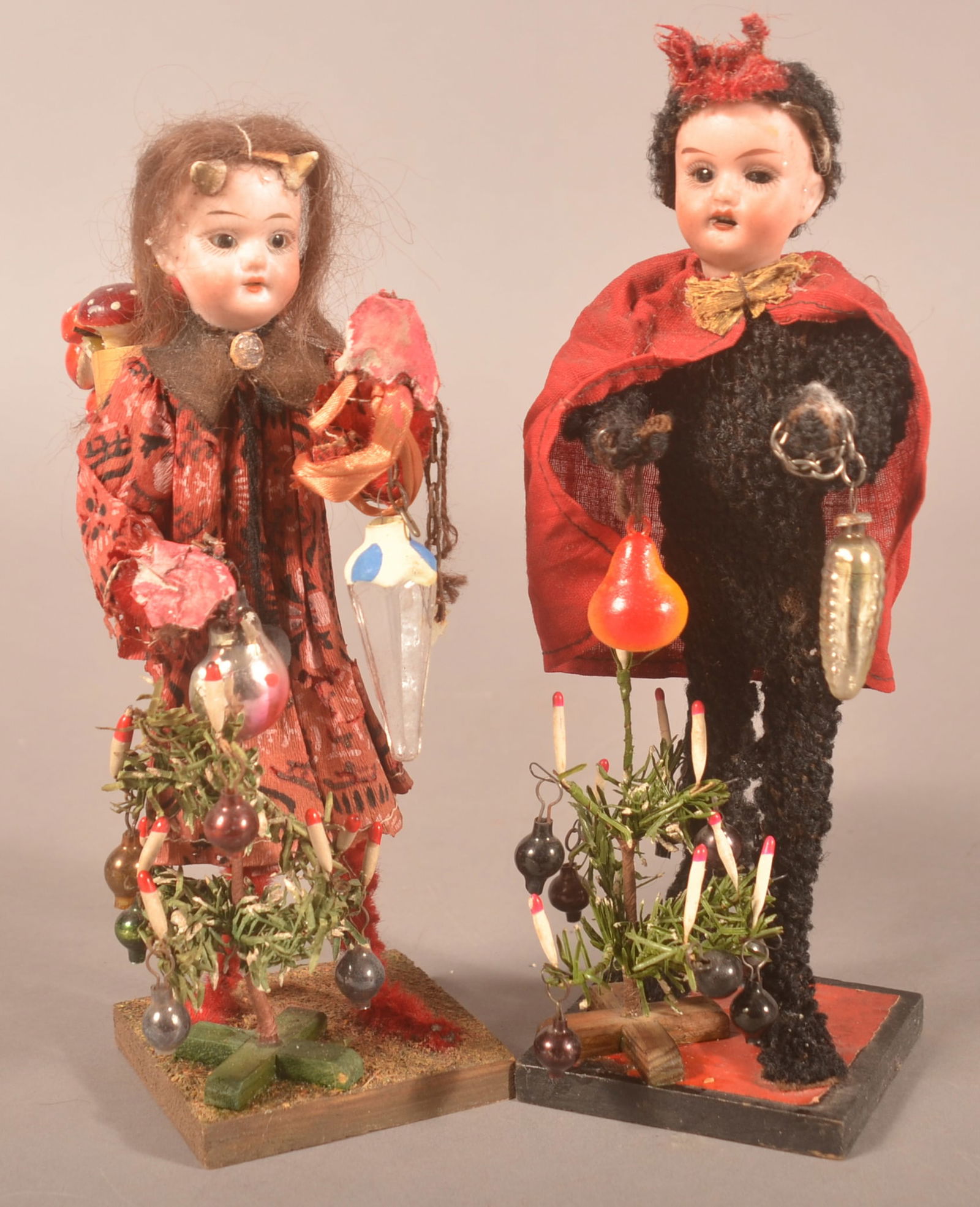 German Krampus Costume Christmas Boy & Girl.: Late 19th/early 20th century. Each holding glass ornaments and candle decorated feather trees with glass ornaments. Girl also has an Adirondack pack filled with mushrooms and ornaments. Both have bisq