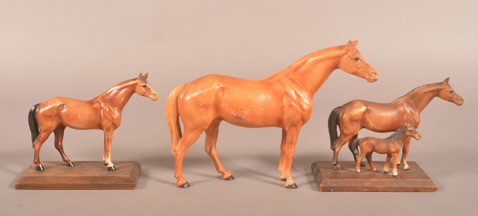 Three Hubley Cast Iron Thoroughbred Horses.: Two are mounted on wood platform bases, (one with colt) and one is a doorstop. All have original paint. Largest, 7-3/4"h. x 2-1/2"w. x 10-1/2"l.