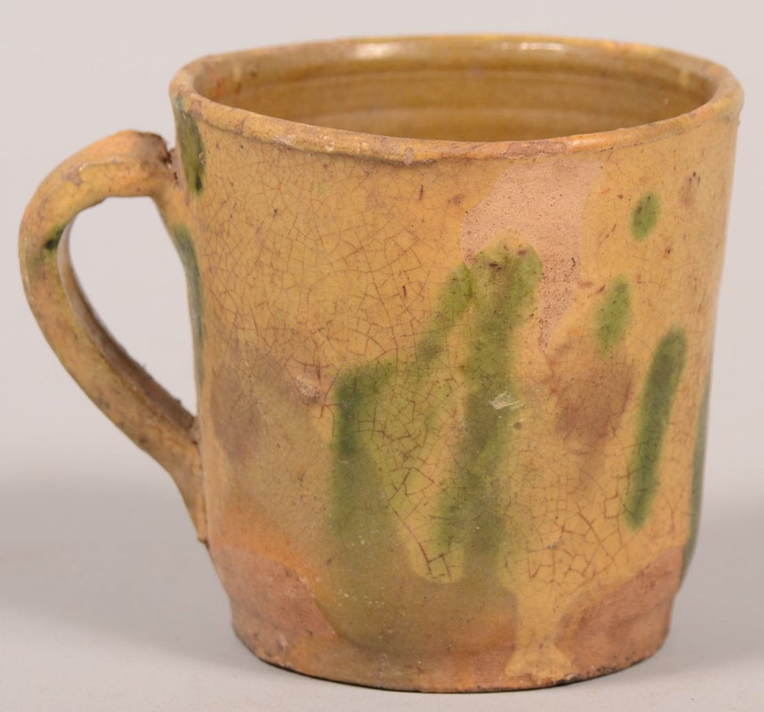 58. 19th Century Earthenware Mug Attributed to Shenando: 58. 19th Century Earthenware Mug Attributed to Shenandoah Pottery. Yellow glaze with green slip blotches. Slightly tapered body with applied loop handle. 3 1/4" high. Condition: Good with minor crazin