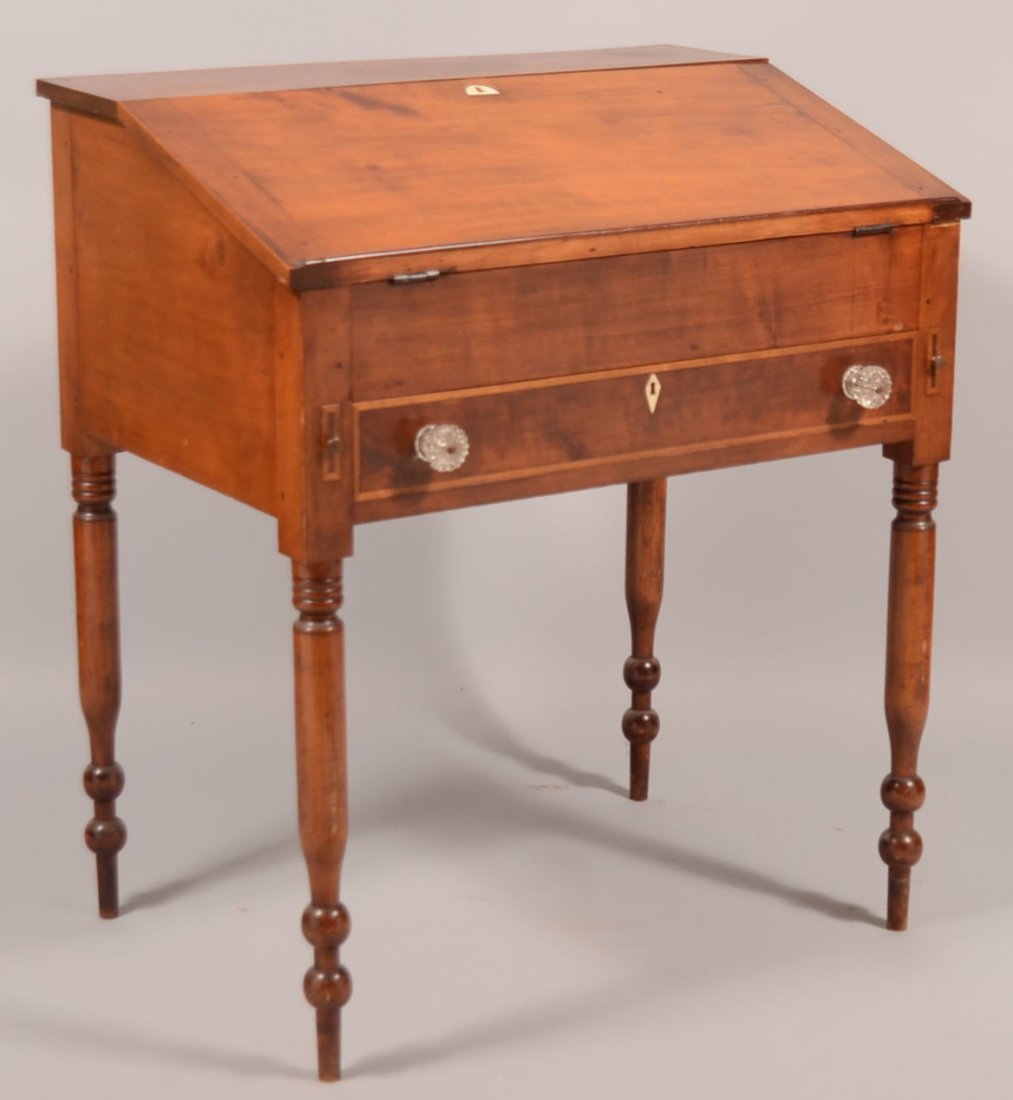 282. Pennsylvania Sheraton Cherry Schoolmaster's Desk. : 282. Pennsylvania Sheraton Cherry Schoolmaster's Desk. Circa. 1820-1840. Slant lid with interior drawers and compartments, full width dovetailed skirt drawer, bone inlaid key escutcheons and boldly tu