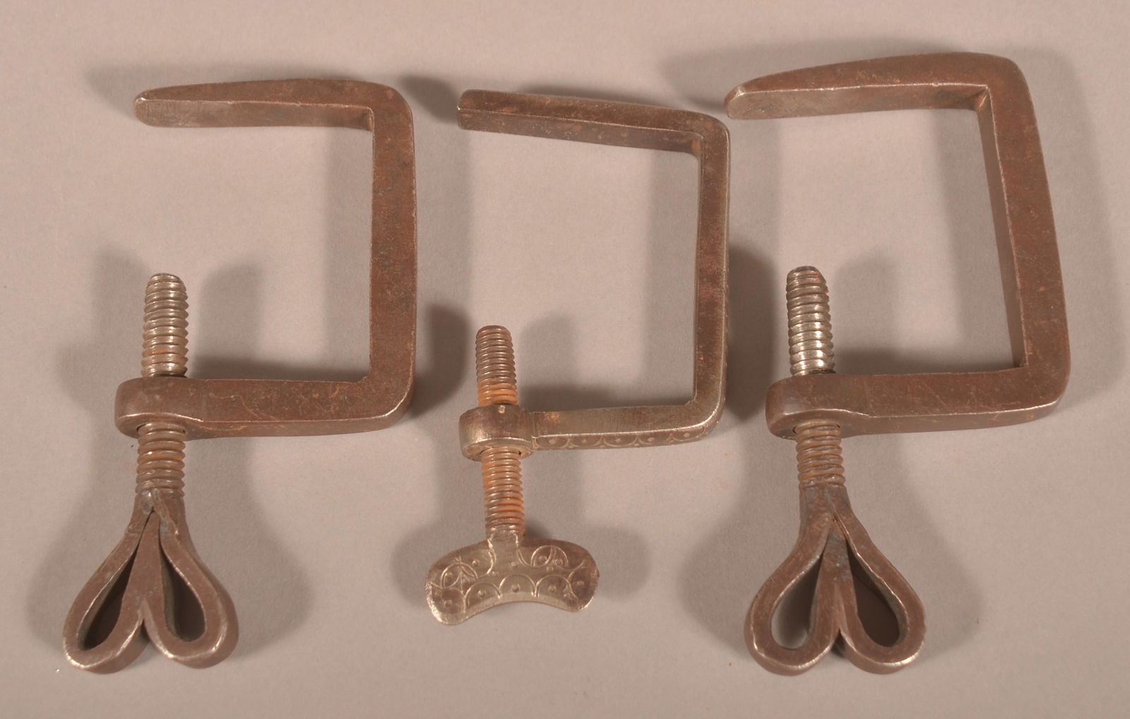 Wrought Iron PA Heart-Shaped Quilt Clamps.: Matched pair with heart-shaped thumb screws and one with dot and vine decoration on the thumb screw and on the front edge of the body of the clamp. Heart, 5-1/4"H (as shown)