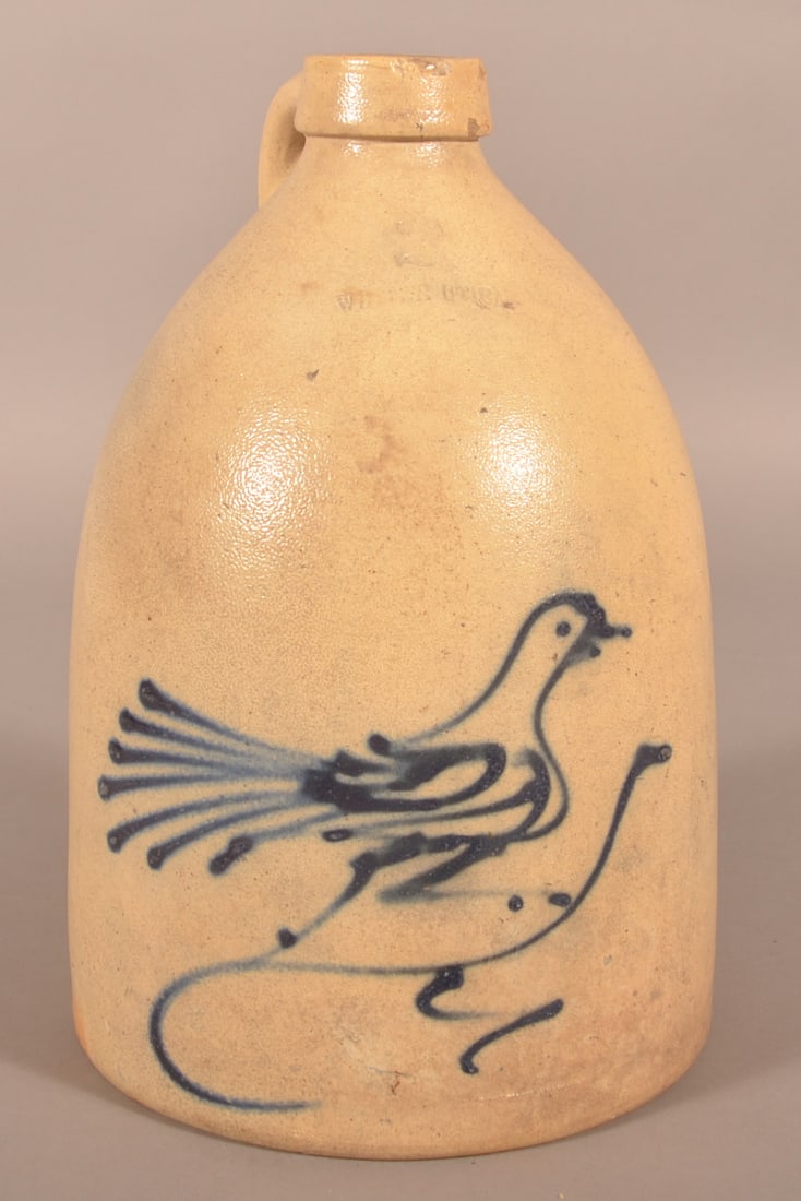2-Gallon Whites Utica Freehand-Decorated Bird Jug.: Nicely shaped jug with clear blue slip-decorated bird. Impressed with capacity mark "2" over Whites Utica. 14-1/4"H x 9-1/4"D