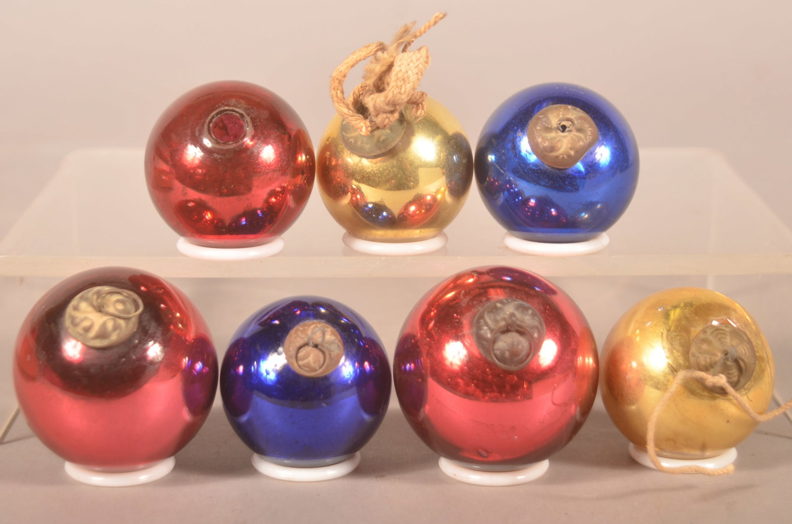 Antique German Glass Kugel Christmas Ornaments: 7 glass kugels with tin embossed caps. 3 red, 2 blue and 2 gold. A couple with period hanging twine still attached. (2) 2"D (4) 1 1/2"- 1 3/4"D