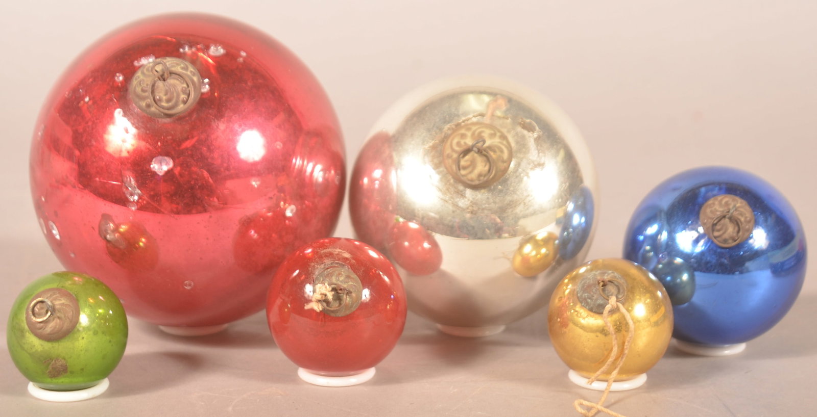 6 Graduated-Size Antique German Christmas Kugels: Attractive group of 6 early glass kugels. 2 with remnants of hanging twine. Tin embossed caps. 2 different shades of red, silver, gold, blue and green. Ranging from 4 1/2"D - 1 1/2"D