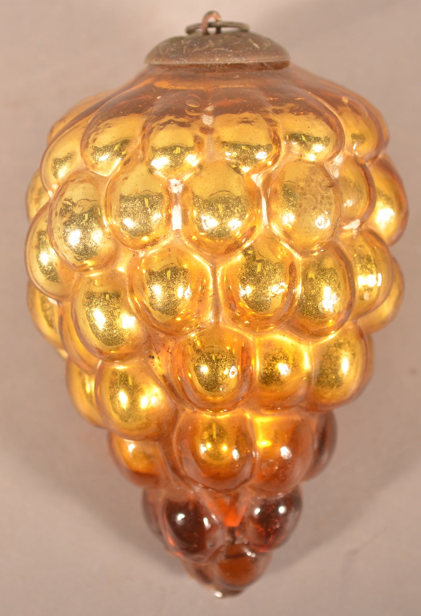Gold Grape Cluster Antique German Christmas Kugel: Interesting color combination with this ornament as it ranges from a nice gold at the top and moves to a honey color at the base. Embossed metal cap. 3 1/2"L