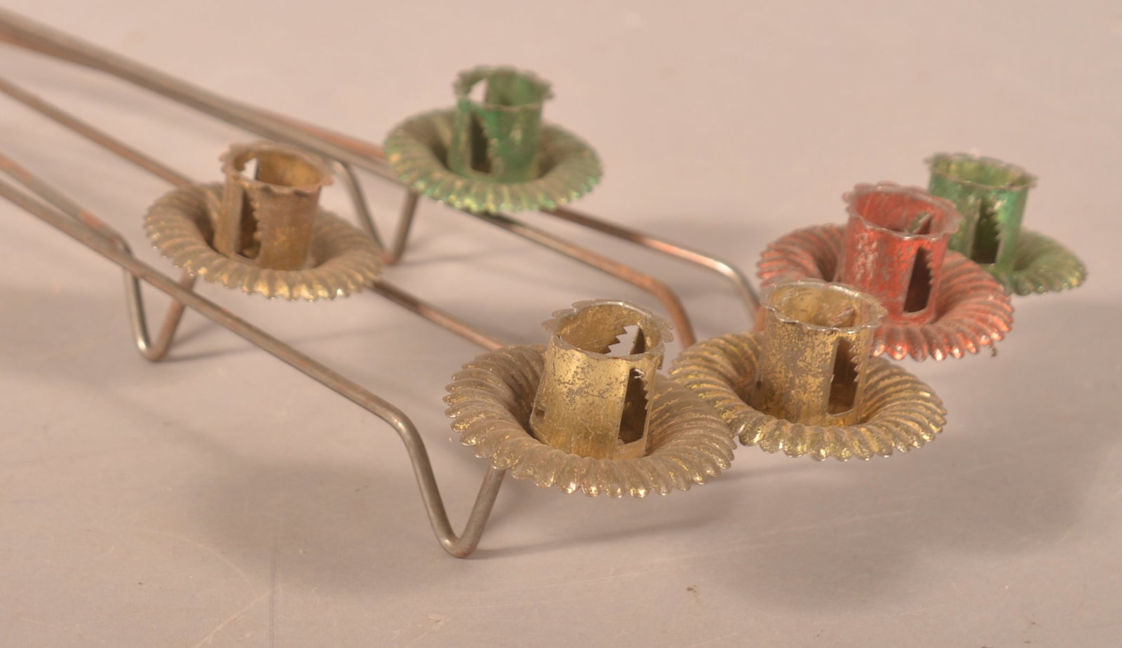 6 Long-Handled Christmas Candleholders: Metal rod with pressed tin candleholders in various colors. End of each rod is threaded to screw in to the tree trunk. Late 19th century. Each, 23 1/2"L