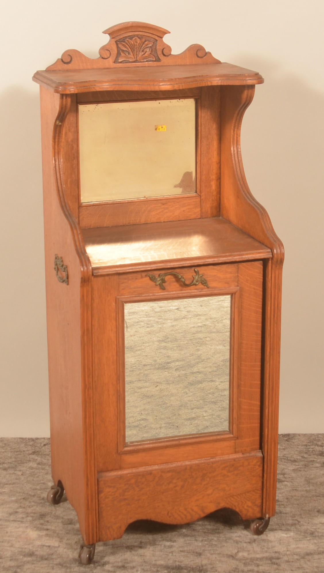 Dainty Victorian Oak & Mirror Carved Coal Scuttle: Original brass handles. Front pulls forward to reveal a tin bin for storing coal. Was repurposed as a garbage can by the consignor. On cast wheels. Nicely shaped apron and feet with carved crest and b