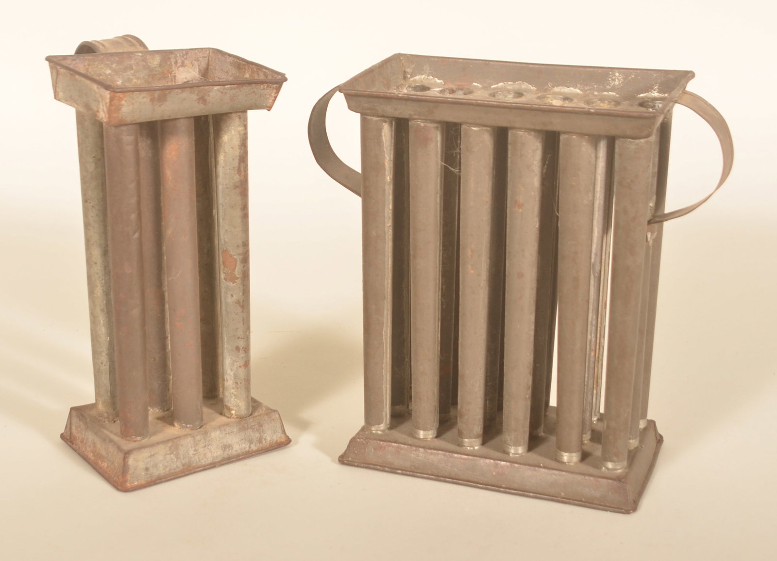 2 Early Pennsylvania Tin Candle Molds: 18-tube and 6-tube. Each with wire reinforced edges. Smaller with pressed design on the handle. 9 3/4"H x 10"W