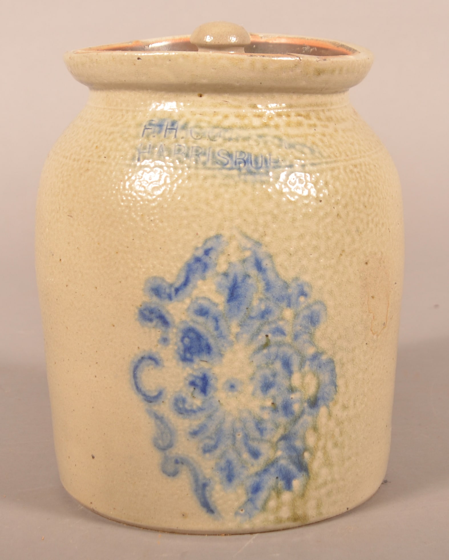 1-Gallon Lidded F.H. Cowden Stoneware Churn: Stamped "F.H.Cowden Harrisburg" with stenciled snowflake design. Includes a stoneware lid. 9"H