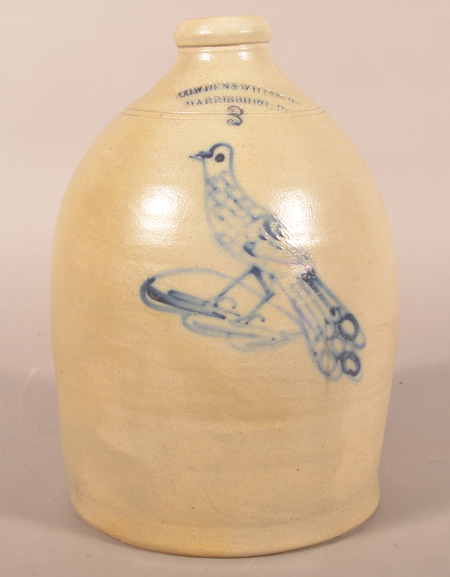 3-Gal. Cowden & Wilcox Cobalt Stoneware Bird Jug: More difficult decoration to find. Freehand bird with long tail on a leaf under the stamped makers mark and capacity number. Blue highlights around the handle. Ca.1860-1865. 15"H
