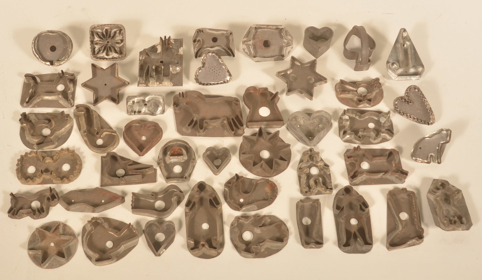Early Tin Cookie Cutters: Excellent group of desirable cookie cutters featuring many different forms and sizes including an apple, different horses, boots, birds, people, stars and something that looks like a Minion, but is ac