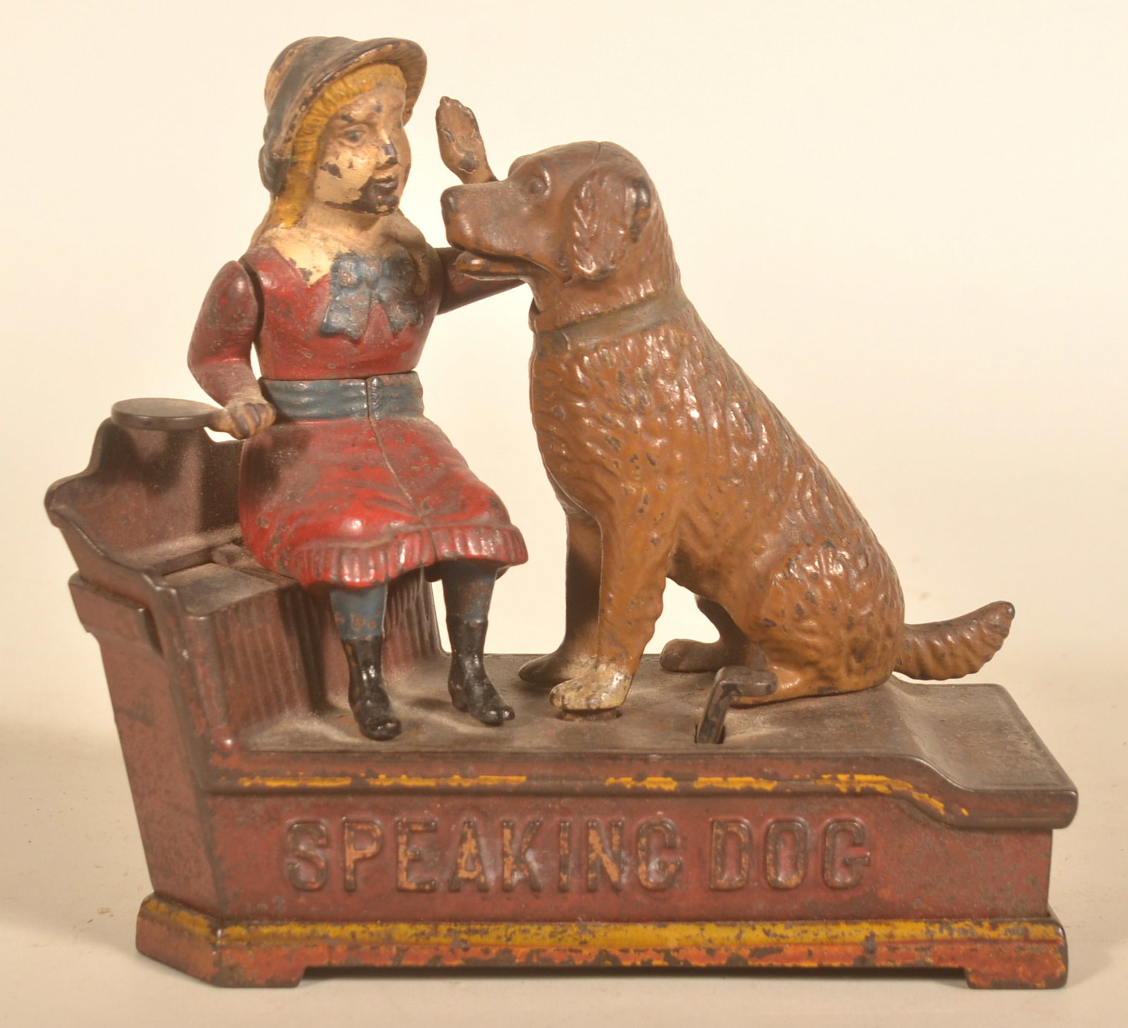 Shepard Hardware Co. Speaking Dog Mechanical Bank: Red dress variation in the original paint. Marked on base "Pat July 14 1885 and Oct 20 1885". 7 1/4"H x 7 1/2"L