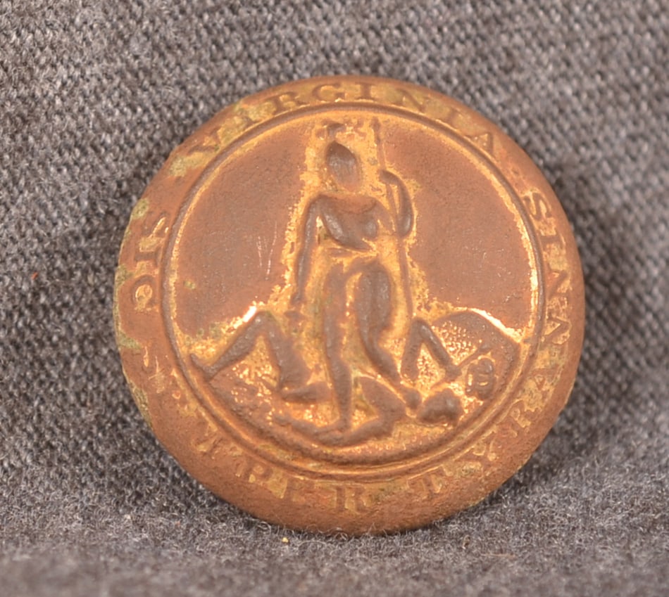 Civil War State of Virginia Dug Coat Button: Nice dug example retaining traces of gold gilt. State seal and motto on front, reverse marked "Scoville Mfg Co. Waterbury". Provenance: The collection of Craig and Cynthia Wertz. 23 mm