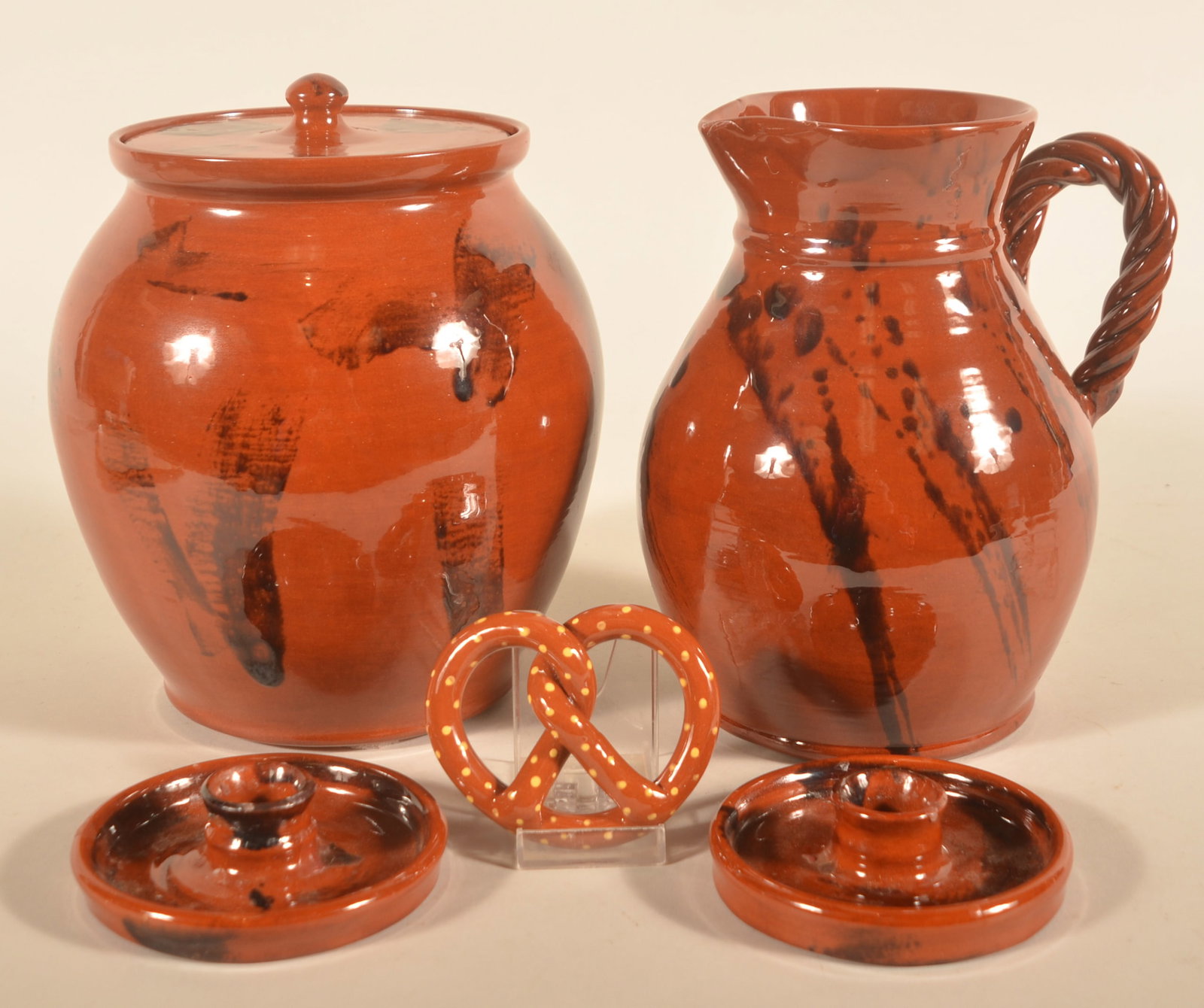 Collection of Breininger Redware: Five pieces in this small collection including a very nice pitcher with twisted handle dated 1984, two candlesticks dated 1985, pretzel ornament dated 1999 and a very large lidded crock dated 1987. Li