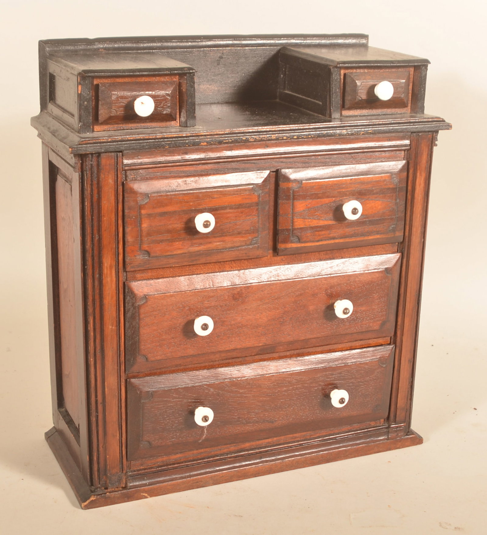 Miniature Child's Antique Dresser: Nicely proportioned homemade mixed wood dresser, tiny square nails,1870s time period. Drawer fronts are mahogany with a raised panel design. Original stained finish has darkened with time. Two glove d