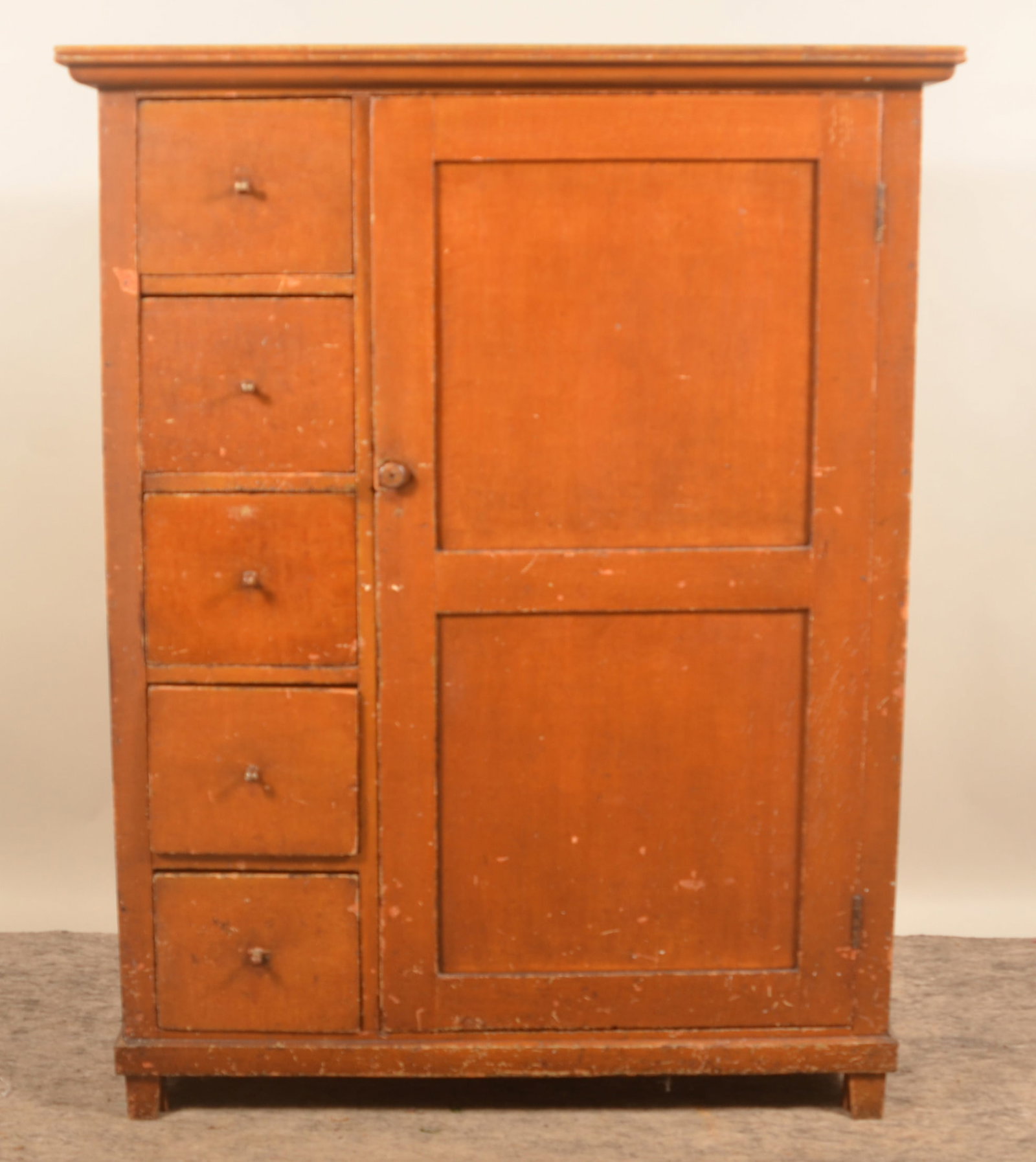Pennsylvania Cupboard w/ Single Door & Drawers: Single door with two recessed panels, five dovetailed drawers with original carved knobs, block feet, applied trim around base and top, and three shelves on interior. Pine with square nail constructio