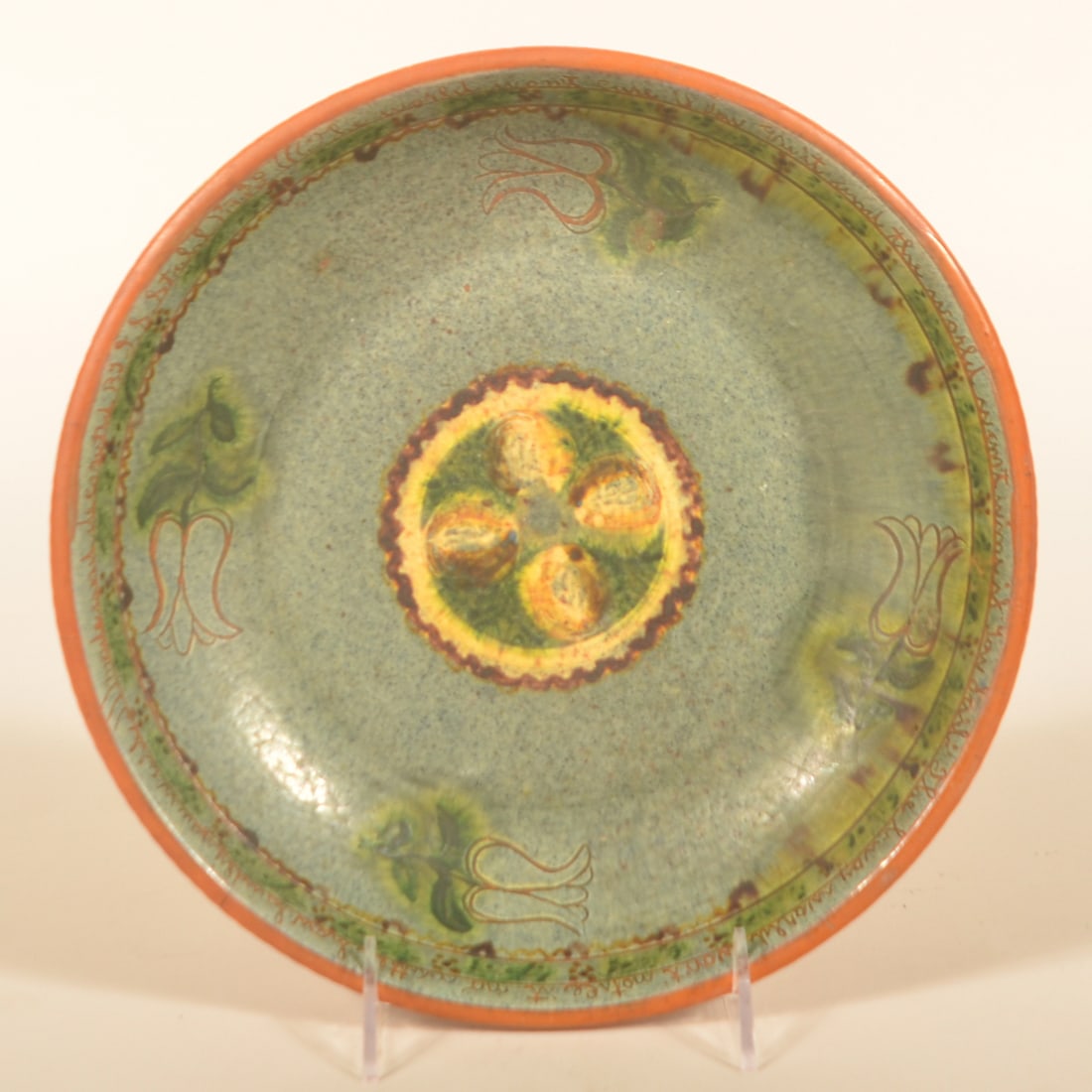Signed & Dated Stahl Decorated Redware Plate: Very nice example of redware from the Stahl pottery with a blue glaze, tulips and a mustard/brown/green bullseye in the center. Dated along the upper edge 7-30-1946 along with the saying "The world