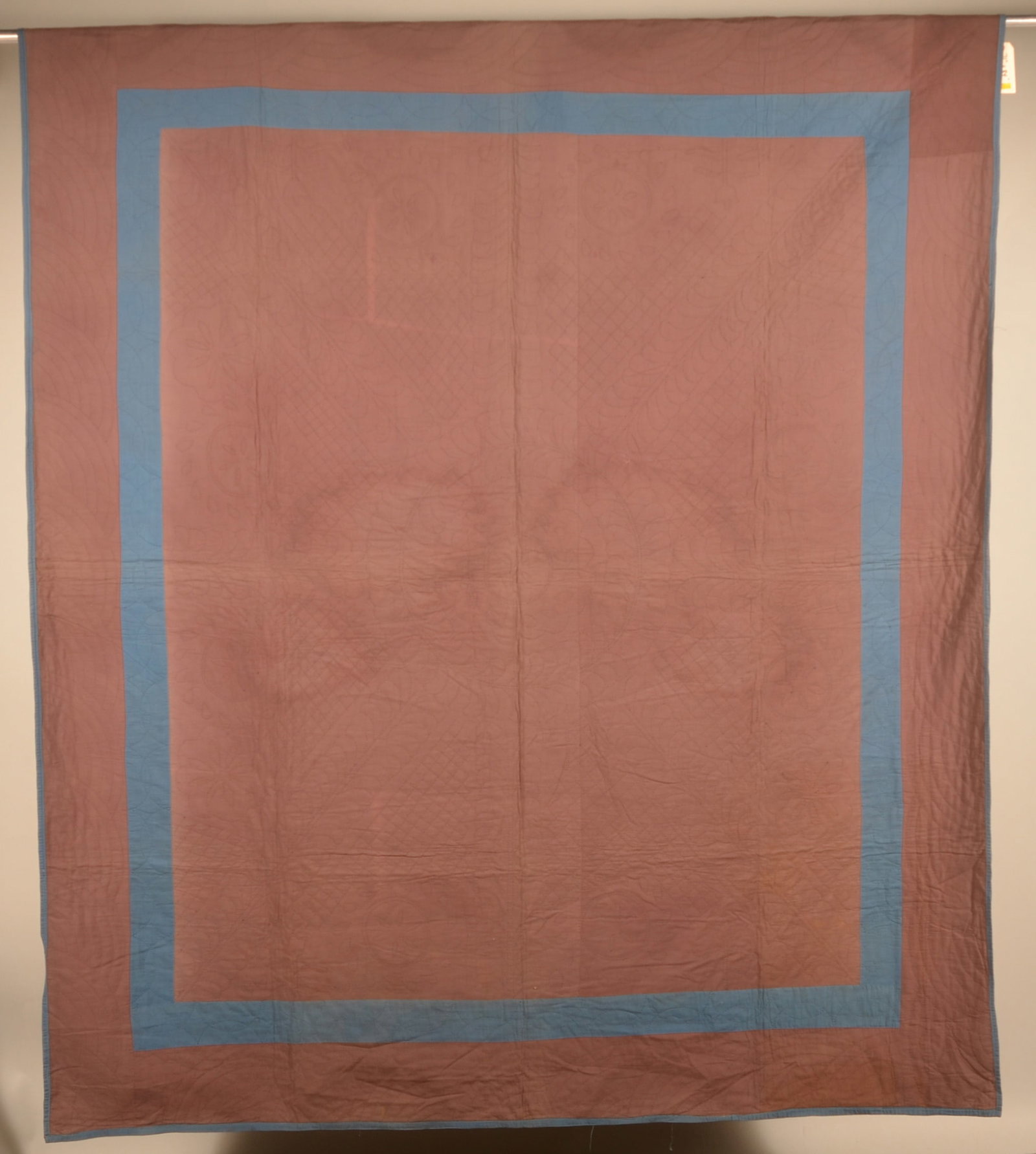 Antique Amish Blue & Brown Hand-Stitched Quilt: Muted chocolate brown color with blue border highlighting an intricate stitching pattern of diamonds, tulips and pinwheels. Border is machine stitched. Early-20th century. 71" x 84"