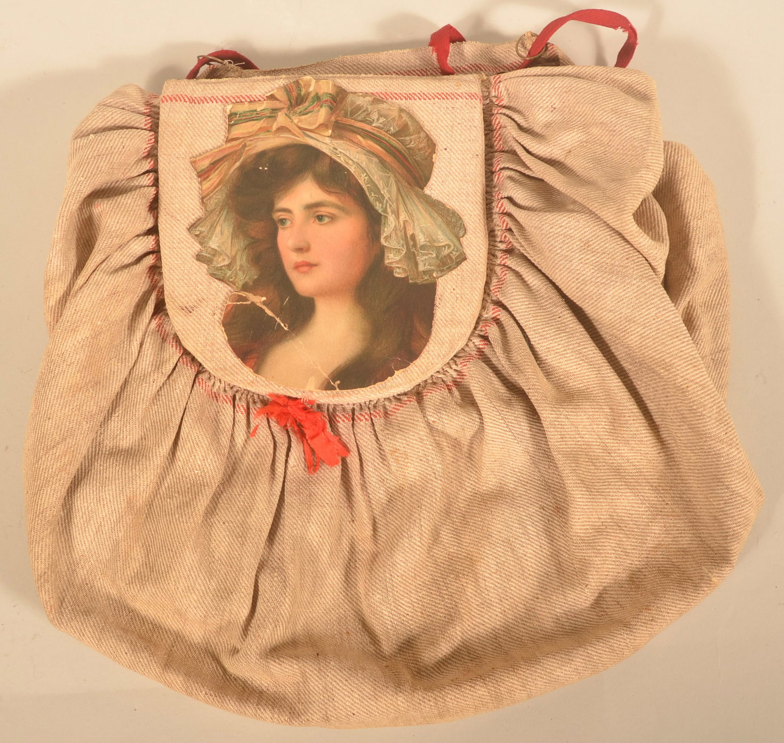 Unusual Handmade Cotton Sewing Bag: Late-19th-century hand-stitched sewing bag with red cotton drawstrings, applied needle holder and an applied Victorian paper cut-out image of a beautiful woman on the closing flap. 14"H x 13"W