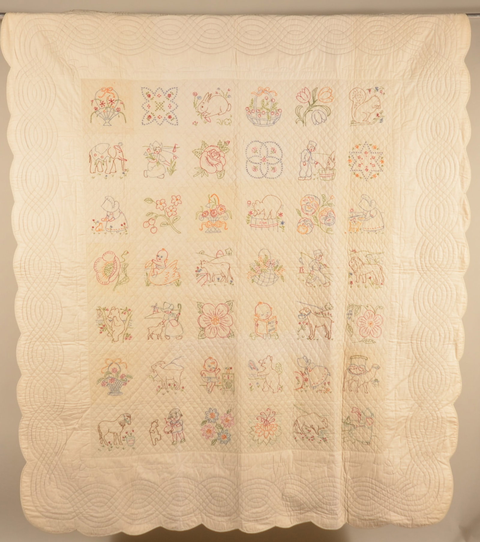 Puss in Boots Vintage Needlework Quilt: Hand-stitched child's quilt, ca. 1930s, featuring various animals and fun scenes including a young child reading the book Puss in Boots. 72" x 82"