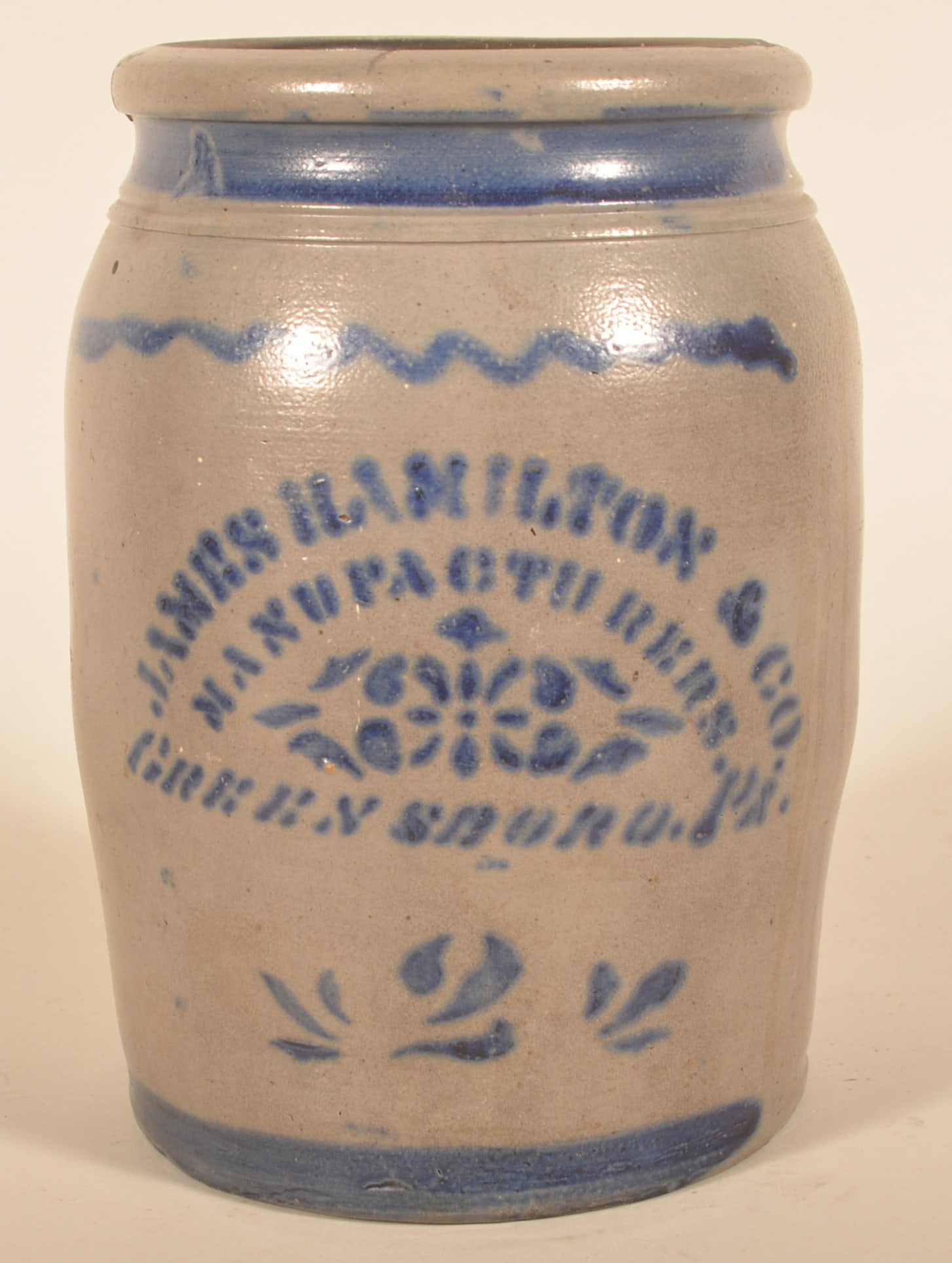 James Hamilton Greensboro, PA 2-Gallon Stoneware: 2-gallon storage jar with deep cobalt blue stenciling and freehand decoration. Note the stencil includes the word "Manufacturers". Ca. 1880. 11 1/2"H