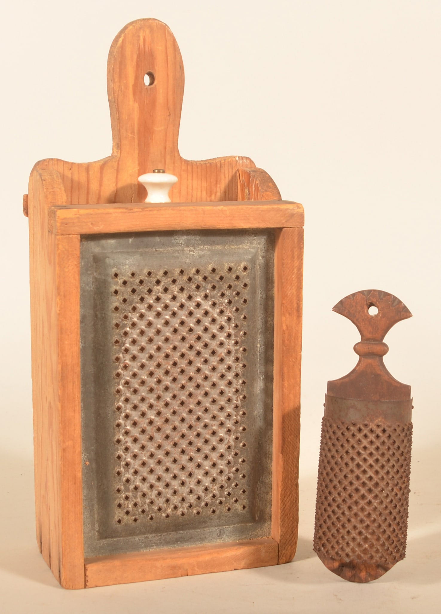 Excellent Antique Hanging Spice Graters: Two items in this group. The first is an early Pennsylvania radius tin grater on a walnut board with tulip carved top. The second is an early-20th-century grater inset in a wood box with a drawer. Scr