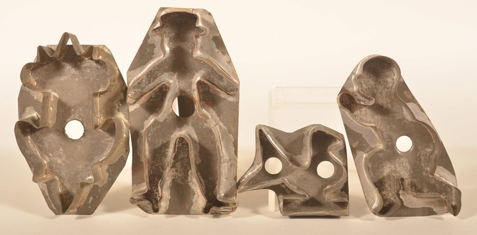 Group of Antique Tin Cookie Cutters: Four figural Pennsylvania tin cookie cutters including a dude with hat, a running child, folky bird with wide tail, and a tulip. Dude, 6 7/8"H