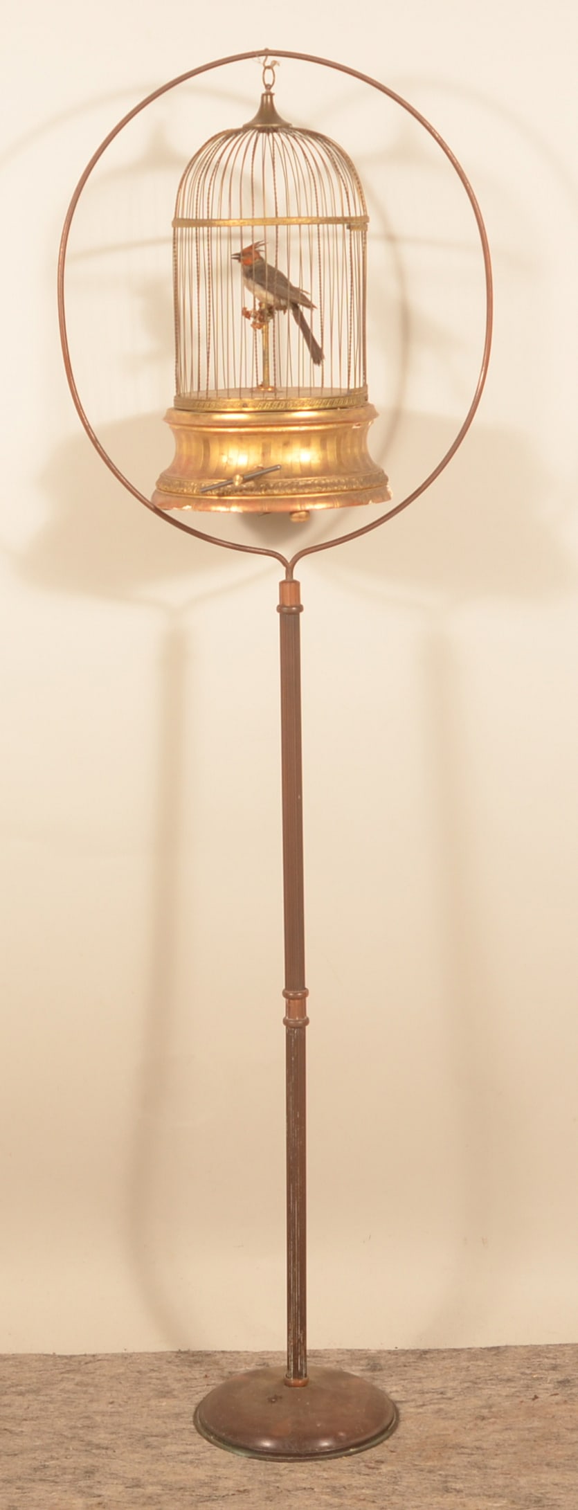 French Automaton Brass Windup Singing Bird Cage: Wonderful 19th-century windup bird cage with a period Arts & Crafts bird cage holder. Bird cage made of stamped brass with a wood base that is gesso painted. When wound, bird moves his head and chirps