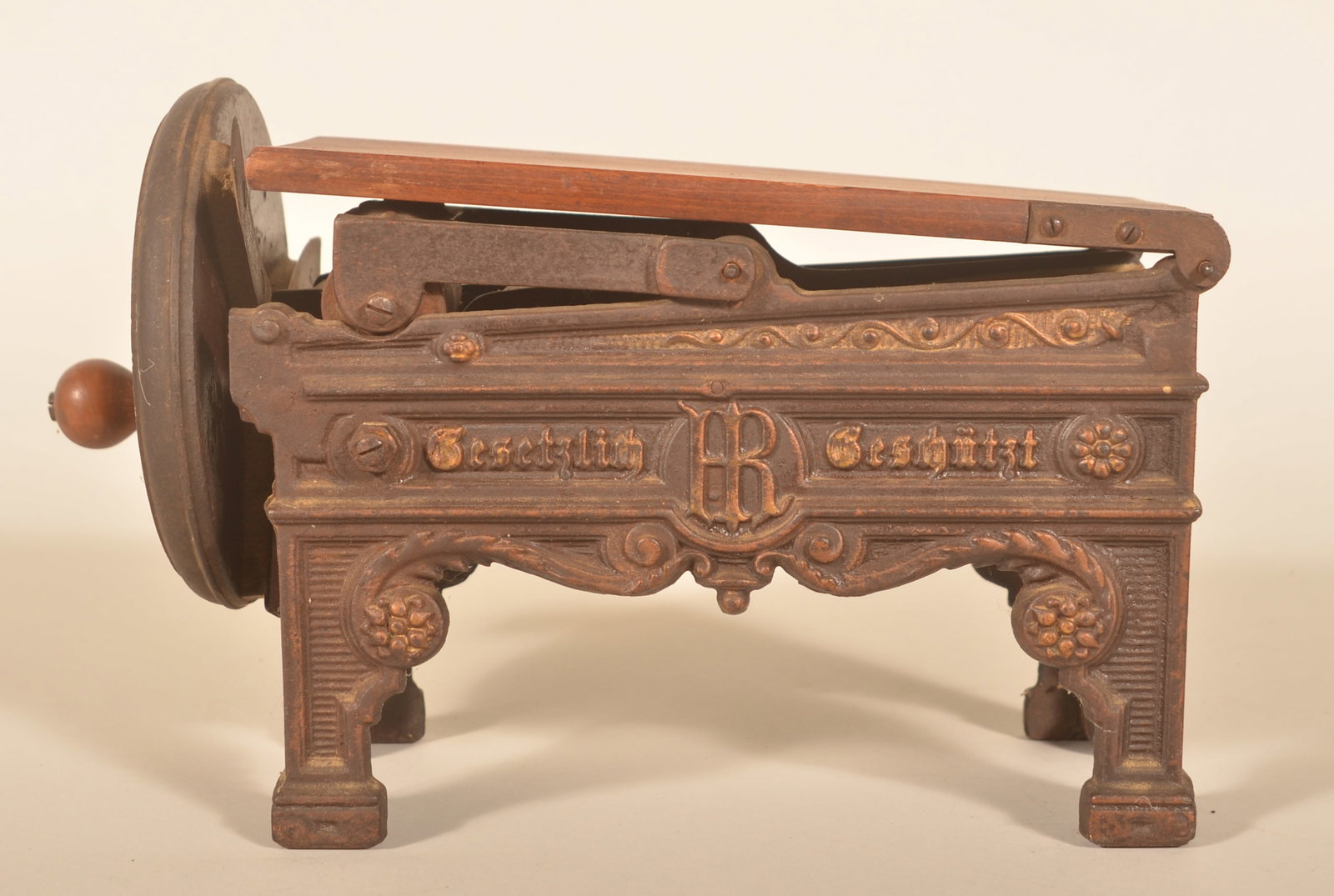 Antique German Tobacco Shredder/Noodle Cutter: 19th-century hand-cranked cast iron machine with wood flip top. The German words indicate the design is protected from copying. Provenance: The collection of Russell and Darlene Snyder. 8"H x 12 1/2"L