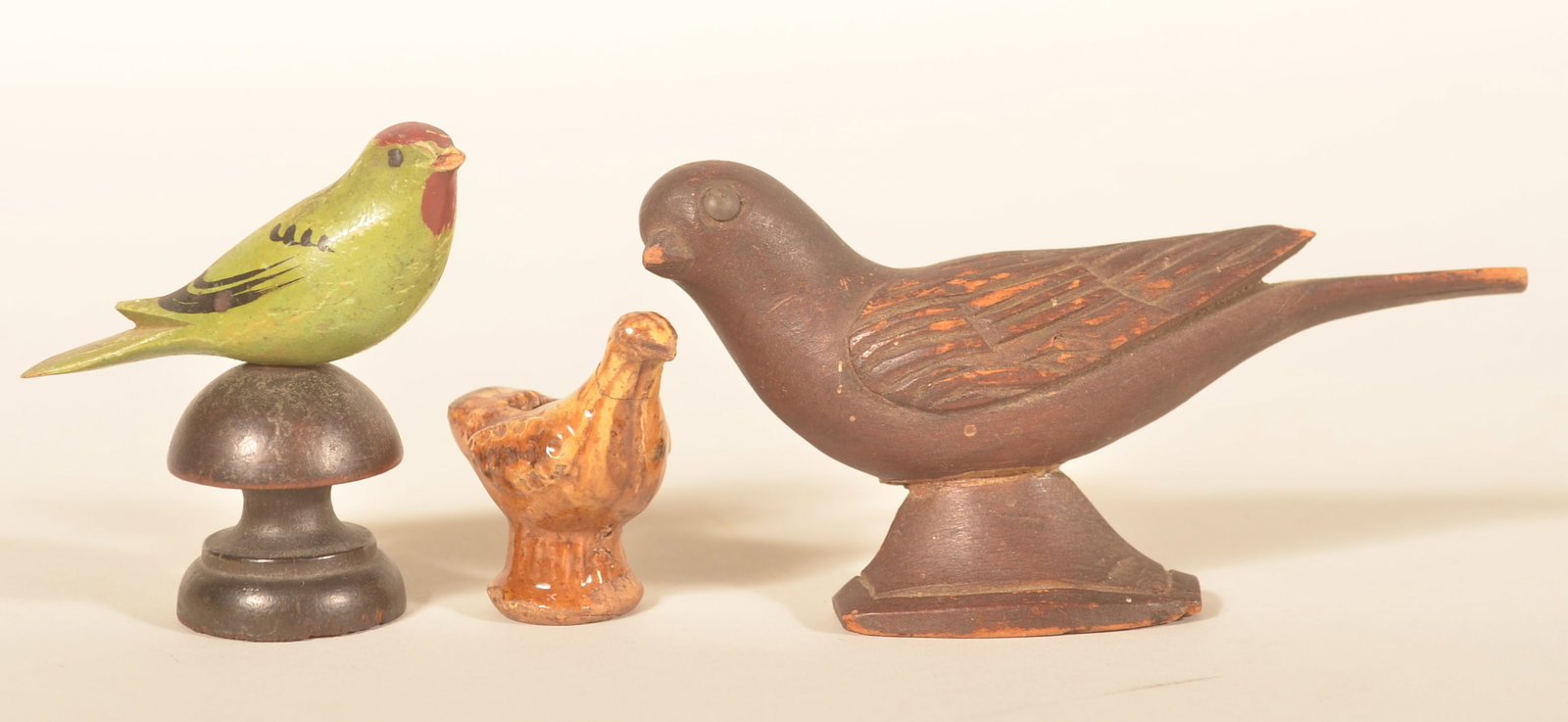 Carved & Paint-Decorated Birds & Bird Whistle: Group of three including a wood carved and painted bird on pedestal, a carved bird on pedestal in a dark original finish and a small bird whistle with Rockingham glaze. Longest, 5 1/2"
