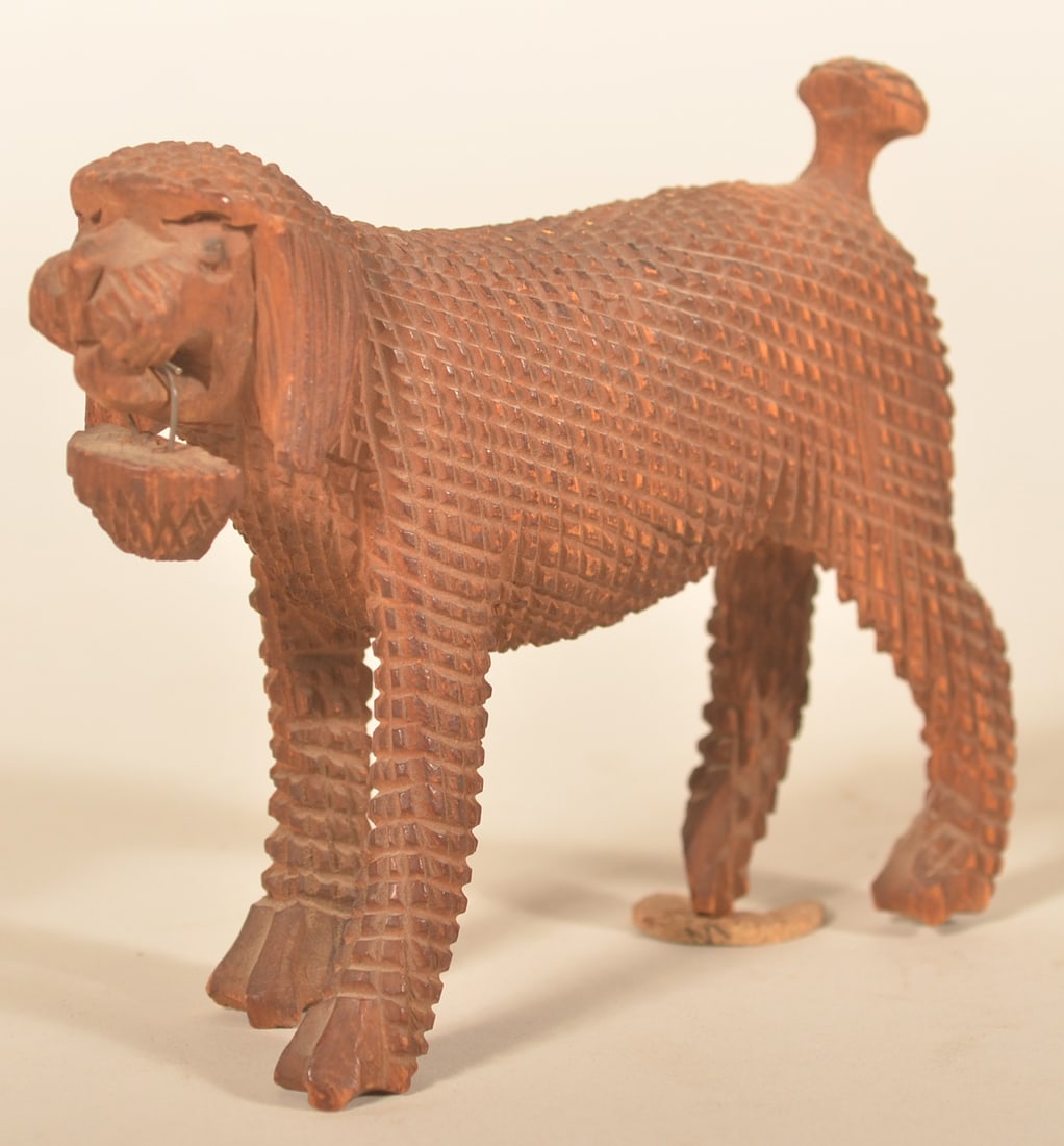 Small Aaron Mountz Carved Dog w/ Basket: Recognizable cross-hatch carving attributed to Aaron Mountz (1872-1949) who lived and worked in Cumberland County, Pa. The dog retains the basket attached with wire to his mouth and his carved tail.