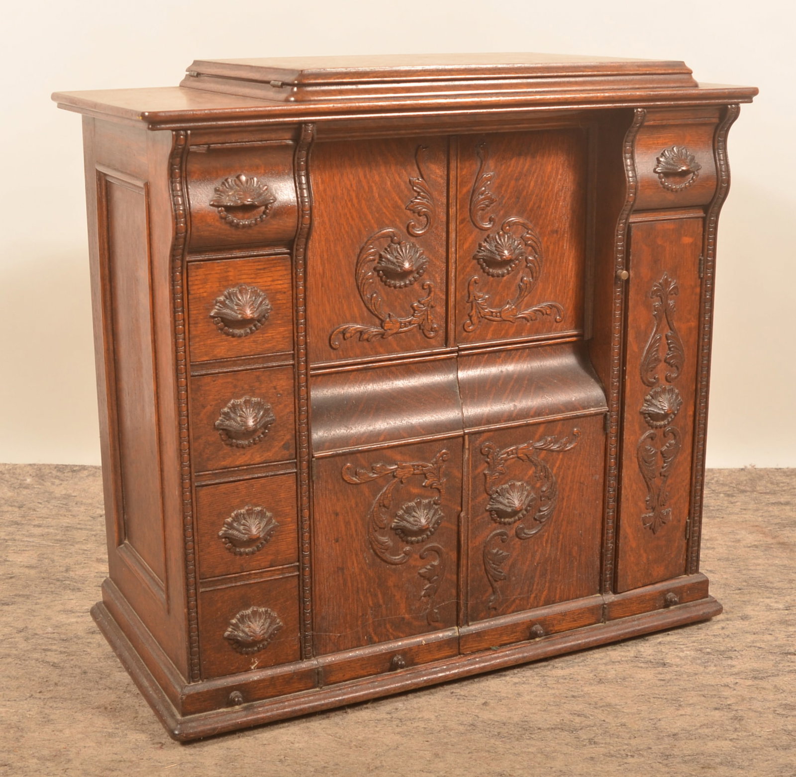 Beautiful 5-Drawer Tiger Oak Singer Sewing Machine: Five drawers to the left, still with sewing accessories, the other doors and false drawer fronts are hinged to allow the sewing machine to raise up. Treadle sewing machine with serial number G1864099 