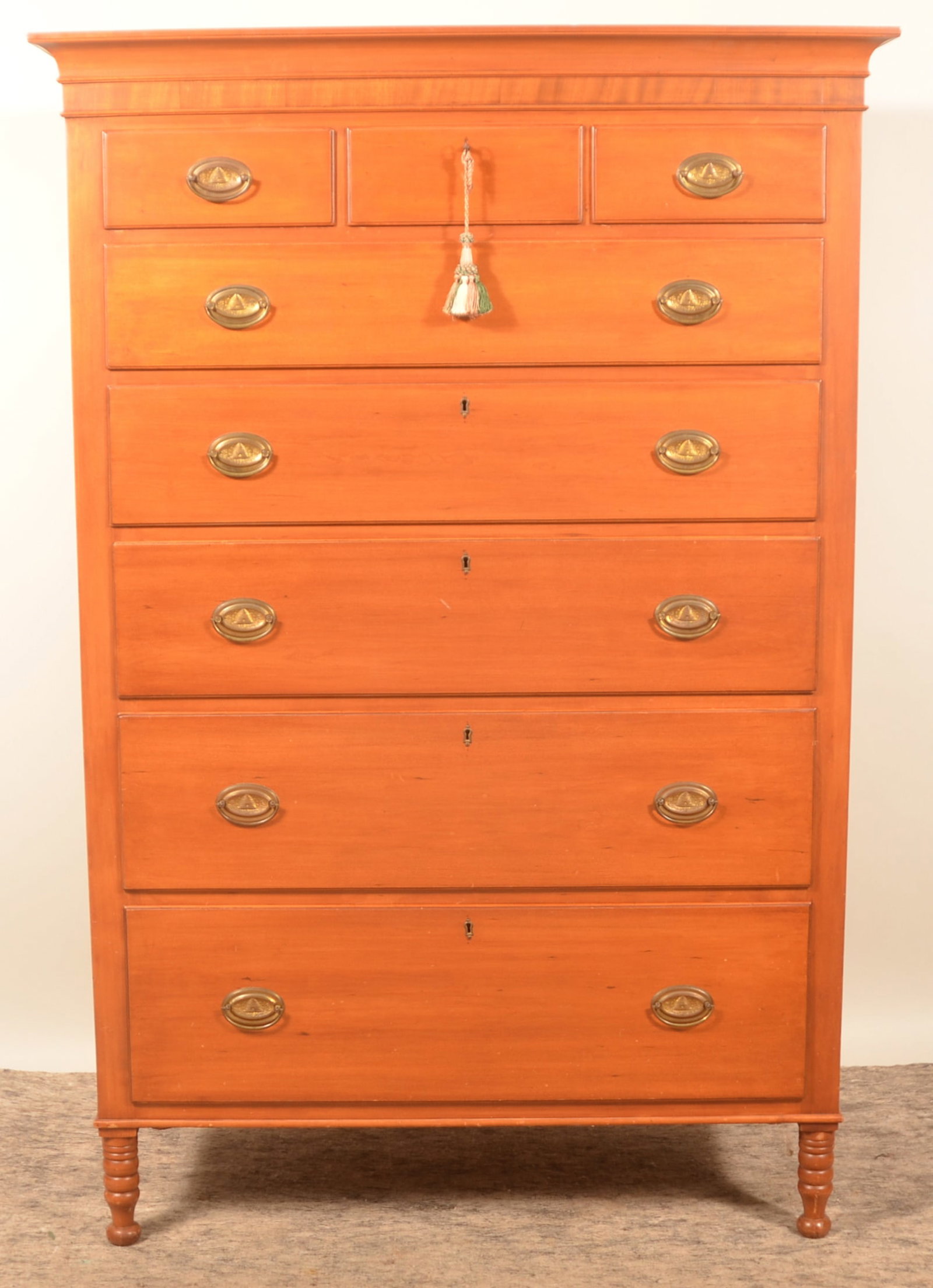 Antique Pennsylvania Tall Chest of Drawers: Cherry tall chest of drawers, three over five. Turned legs, recessed panels on the side, stamped brasses with beehive design. Berks County, Pa. 67 3/4"H x 45 1/4"W x 22"D